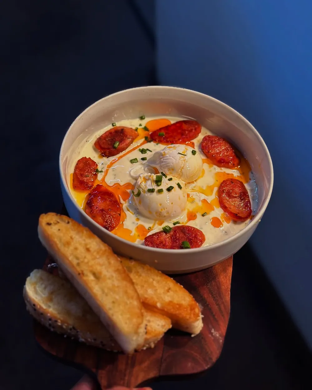 Baked eggs with chorizo in a bowl, toasted sourdough on the side